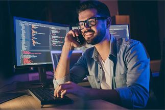 man in front of screen gives customers support via telephone